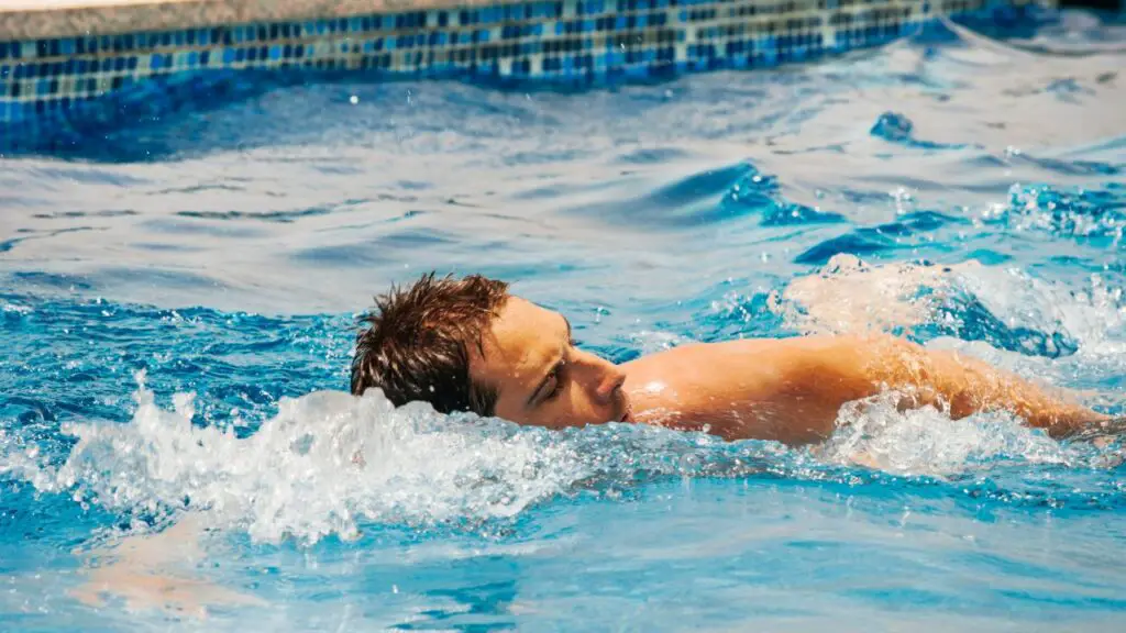 man swimming with headphones on