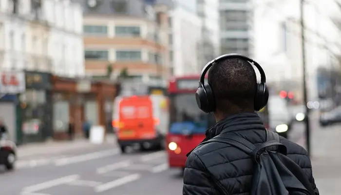 Image of a person listening to music calmly while there is unnecessary sound in background (sound maybe of vehicles, home appliance